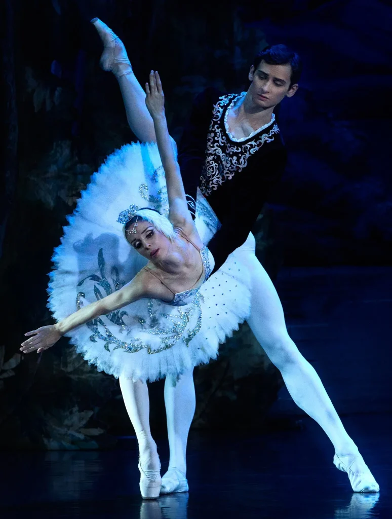 Bailarinas interpretando El Lago de los Cisnes en escenario teatral