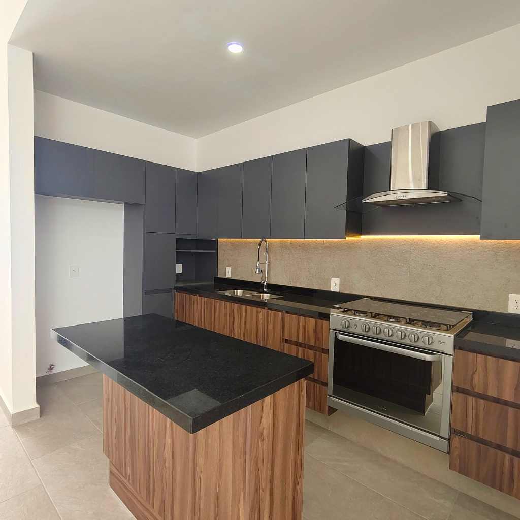 Cocina con isla de granito del modelo Nahil en Canah Residencial León